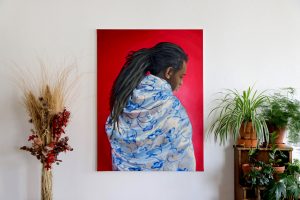 peinture à l'huile d'un homme noir avec un fond rouge et portant un drap bleu et blanc satiné