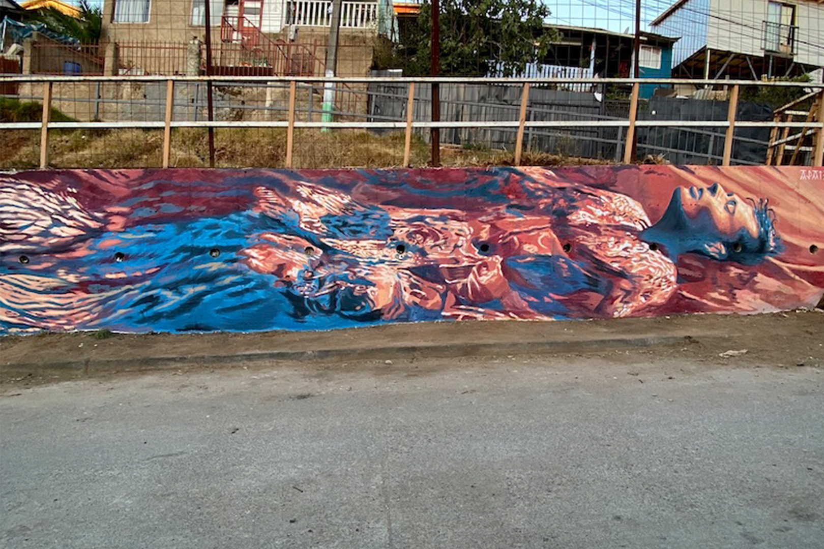 Fresque murale réalisée dans la quartier Placeres à Valparaiso au Chili. La peinture représente un homme flottant dans l'eau avec des couleurs orange et bleu.